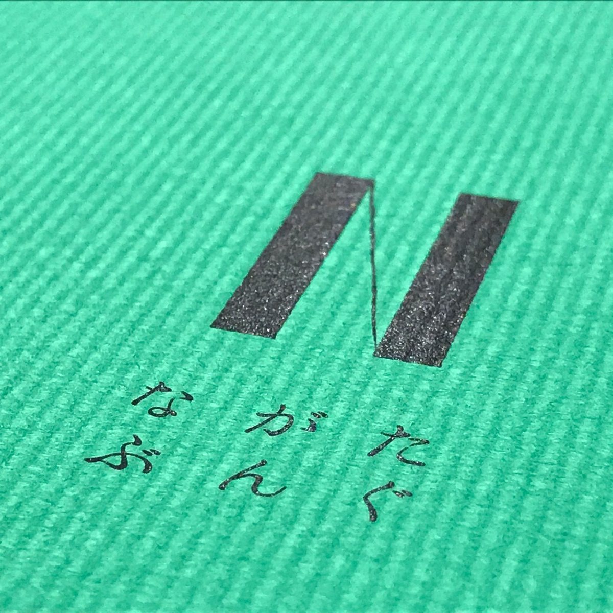 ミントグリーンの紙に押されたロゴ